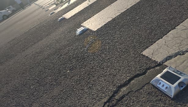 Solar road studs installed on asphalt pavement, showing spacing layout in daylight