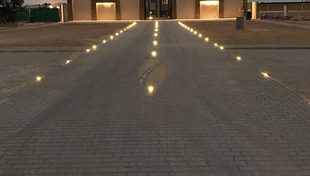 Solar road studs in straight spacing arrangement on driveway at night, enhancing visibility